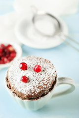 Powdered mug cake with cranberry on table