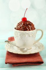 Chocolate mug cake with cream and cherry on napkin on table