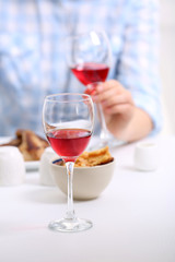 Dinner with glasses of wine on light blurred background