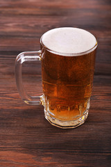 Glass of beer on wooden background