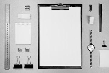 Office set with white sheets of paper, watch and stationery on grey background