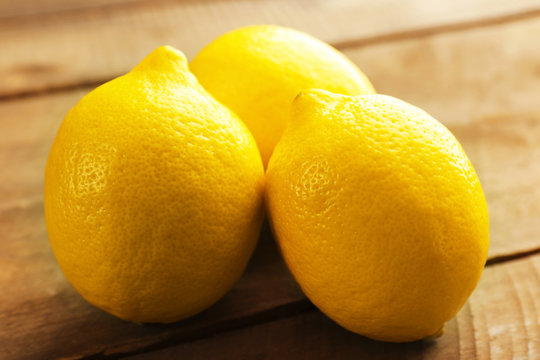 Fresh lemons on wooden table closeup