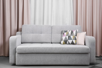 Grey sofa against curtains in the room