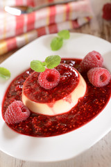 Panna cotta dessert with fresh raspberries and mint leaves on to