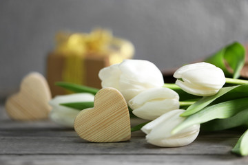 Fototapeta na wymiar White tulips on a wooden table, close up