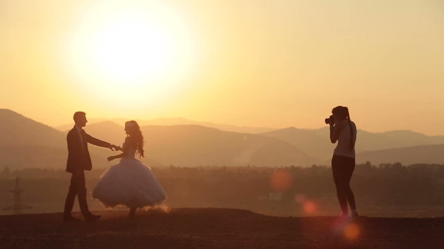 Woman-photographer takes photos of wedding couple in the Alpine mountains