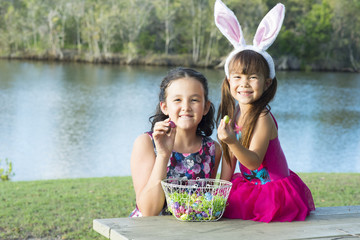 復活祭、エッグハントの後仲良くチョコレートをバスケットから取って食べる姉妹。