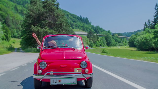 Senior lady lifting her hands up in a zastava car