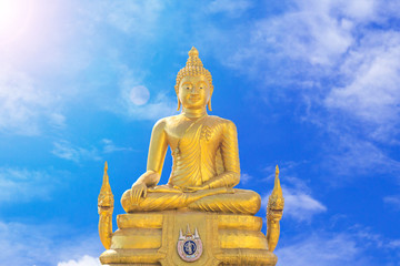 Fototapeta premium Golden Buddha statue on blue sky background