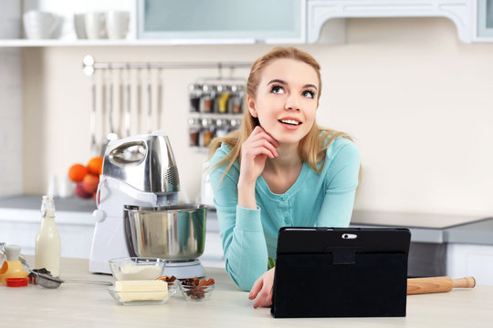 Young woman using a tablet computer to follow a recipe