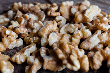 Shelled walnuts on wooden cutting board background from side closeup