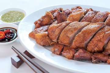 Roast duck, Chinese style on the white dish and white tablecloth