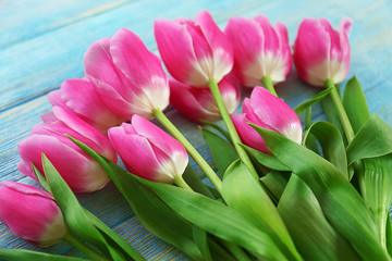 Fresh pink tulips on a wooden table, close up