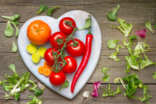 Fresh spring vegetables on wooden heart health lifestyle diet concept
