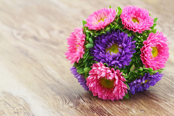 Colorful daisy bouquet on wooden surface with copy space
