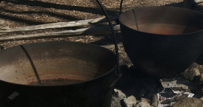 Sap boiling in old metal pots to produce maple syrup during harvest season in Canada
