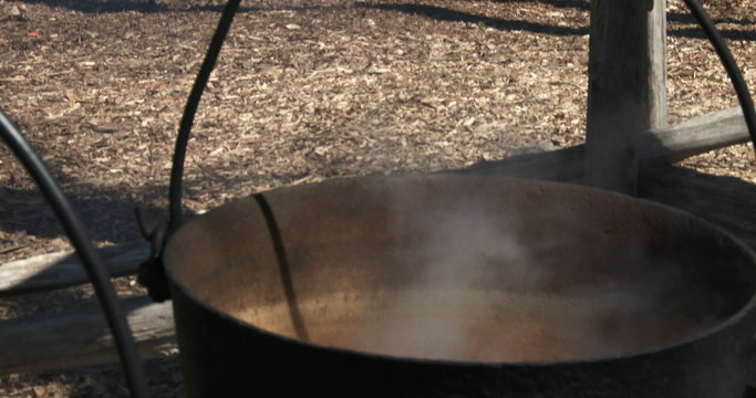 Sap boiling in old metal pots to produce maple syrup during harvest season in Canada
