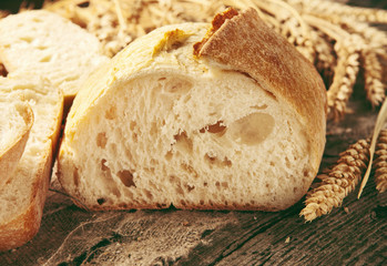 cut loaf of bread with ears of wheat