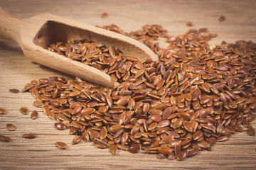 Vintage photo, Heap of linseed with spoon on wooden background