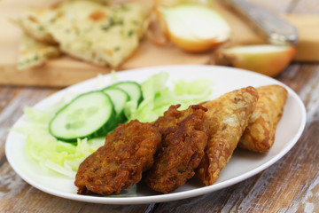 Indian snacks including onion bhajis and samosas, and green side salad
