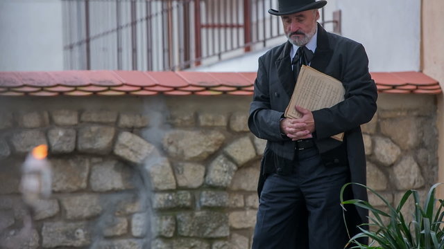 Man walk to the stone table with cylinder on his had 