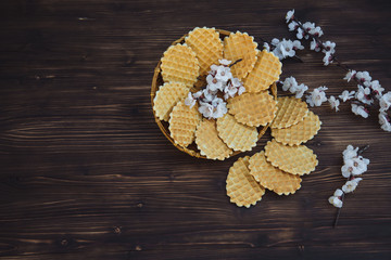 Sweet waffles on a wooden background with flowers