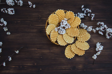 Sweet waffles on a wooden background with flowers