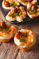 Freshly baked muffins with sausage, cheese and onion closeup. Vertical
