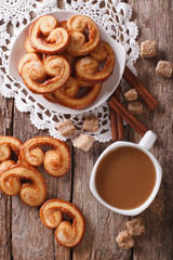 Coffee and cookies Palmiers close-up on the table. vertical top view 

