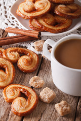 cookies of puff pastry Palmiers and coffee with milk close-up, vertical
