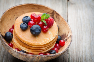 Stack of pancakes with blueberry and fresh berry.