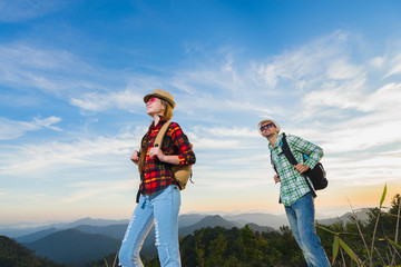 Travel concept. Hikers with backpacks walking in mountains at sunny day.