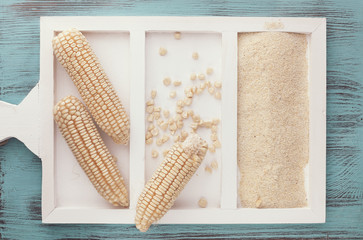 White corn on the cob and corn flour on rustic background © happyimages