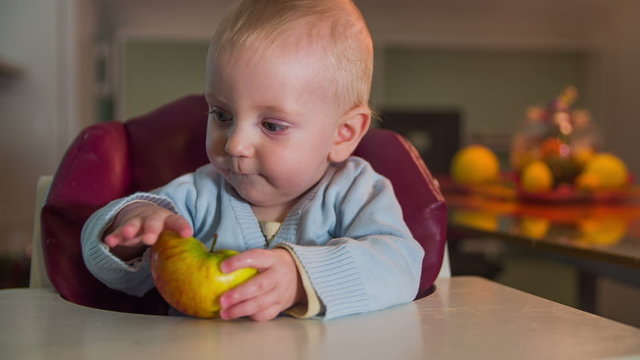 Just born child with half an apple in his hands 