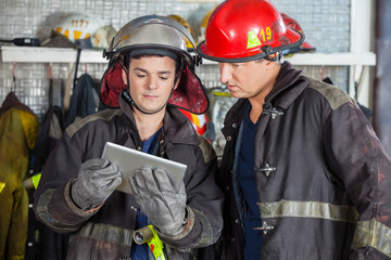 Obraz premium Firefighters Using Digital Tablet At Fire Station