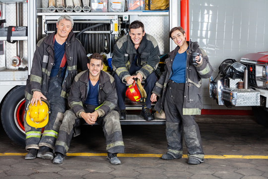 Portrait Of Confident Firefighters By Truck
