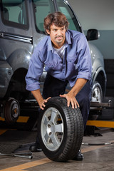 Fototapeta na wymiar Mechanic Holding Car Tire
