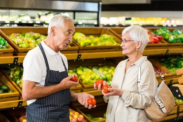 Senior customer and worker discussing vegetables