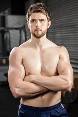 Determined shirtless man with arms crossed