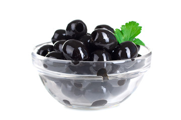 a bunch of delicious and healthy olives pitted with green leaf in glass bowl on white isolated background