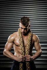 Obraz premium Shirtless man with battle rope around neck