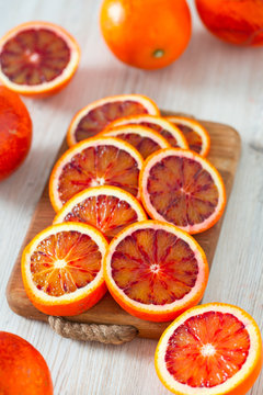 cut blood oranges on wooden surface