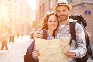 Couple of young attractive tourists watching map