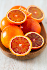 cut blood oranges on wooden surface