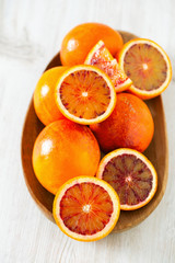 cut blood oranges on wooden surface