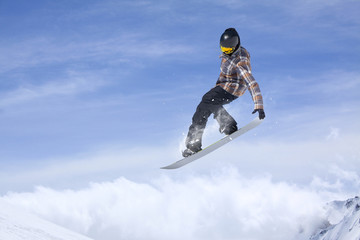Fototapeta na wymiar Snowboard jump on mountains. Extreme sport.