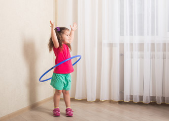 smiling girl with hula hoop at home - Powered by Adobe