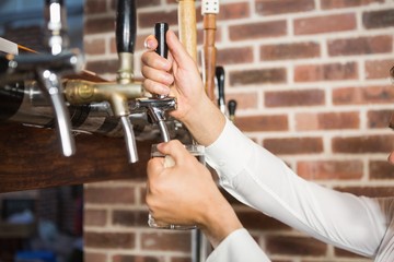 Masculine hands pouring beer