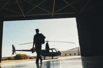 Naklejka premium Helicopter pilot arriving at airplane hangar