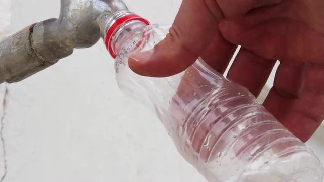 Man pours tap water into a bottle